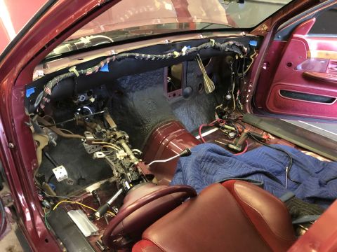 1992 Ford Crown Victoria - The interior of a maroon vehicle is shown with the dashboard disassembled for repairs.