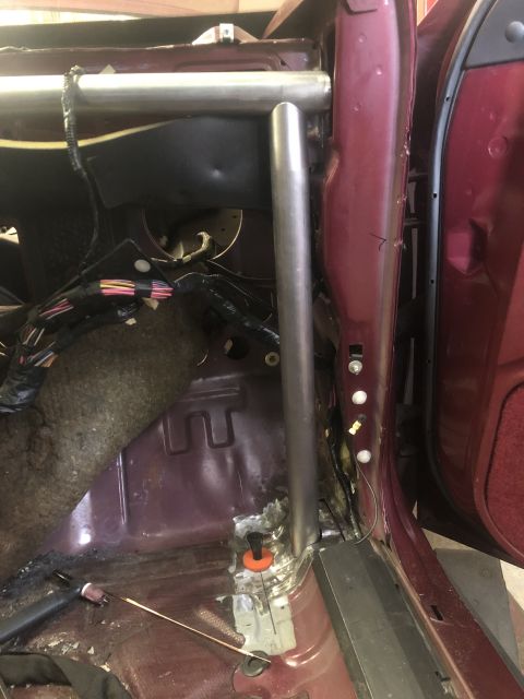 1992 Ford Crown Victoria - A custom roll cage is being installed inside a maroon vehicle's interior.