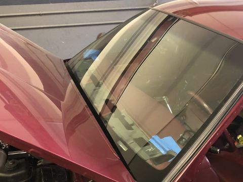 1992 Ford Crown Victoria - The hood of a car is open, revealing the windshield with blue tape applied to the glass.