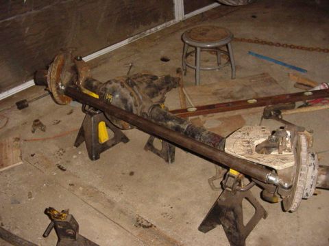 1992 Ford Bronco - A differential axle assembly is supported by jack stands in a workshop environment.
