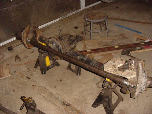 Differential axle assembly on jack stands, with brake rotor and caliper visible