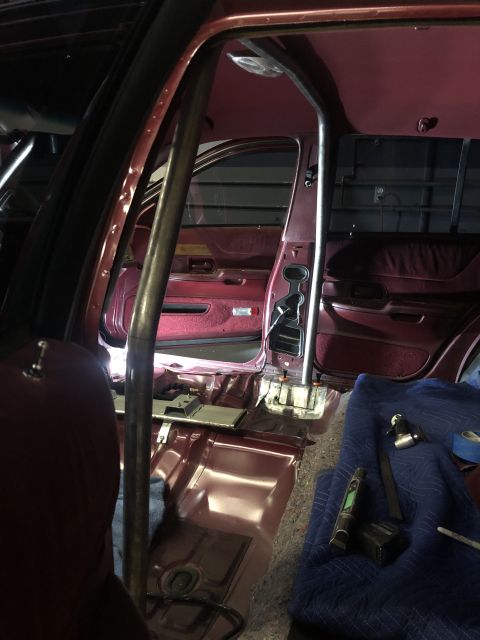 1992 Ford Crown Victoria - The interior of a car is shown with a newly installed roll cage and some tools laid out.