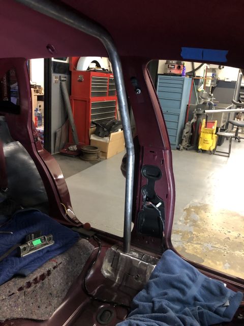 1992 Ford Crown Victoria - The interior of a 1992 Ford Crown Victoria shows a roll cage installation and maroon upholstery.