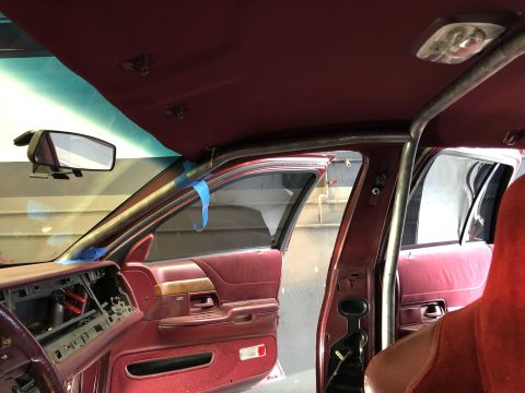 1992 Ford Crown Victoria - The interior of a 1992 Ford Crown Victoria shows a roll cage installed, with the dashboard and door panel visible.