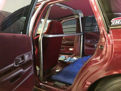 1992 Ford Crown Victoria - The interior of a car is shown with a prominent roll cage installed, covering the rear seating area.