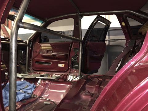 1992 Ford Crown Victoria - The interior of a 1992 Ford Crown Victoria is visible, a custom roll cage and stripped-down carpeting.