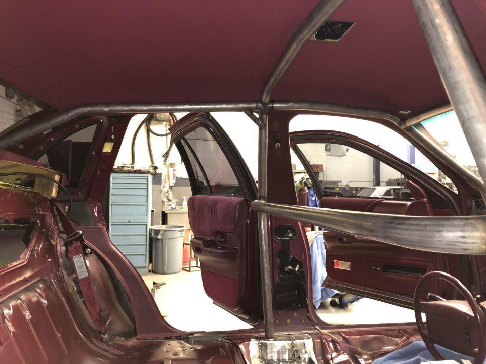 Maroon interior of a 1992 Ford Crown Victoria with a roll cage installed