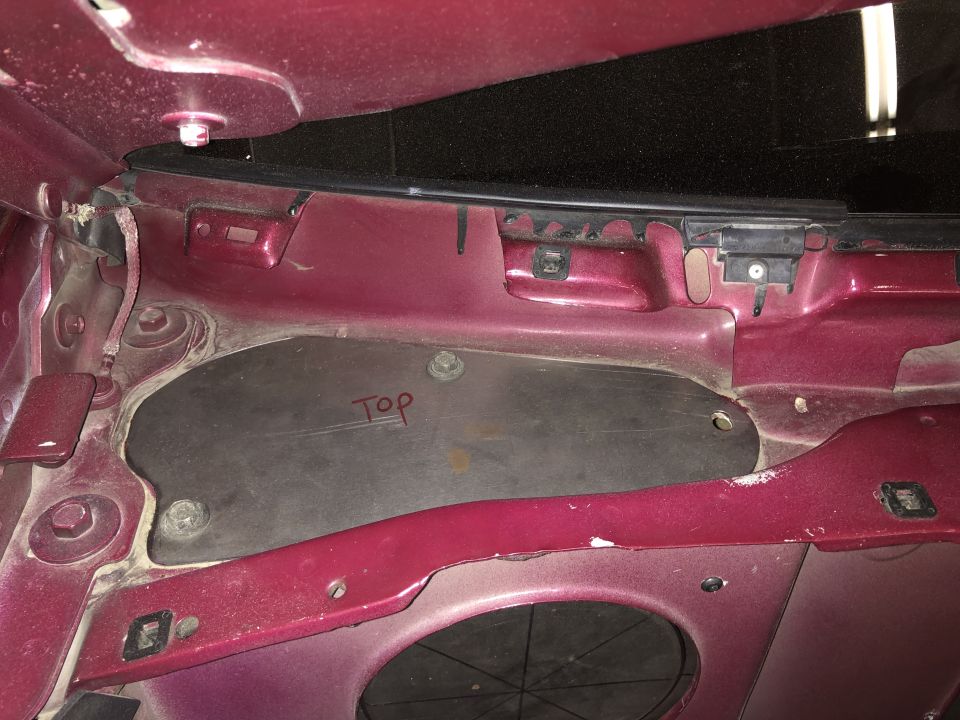Maroon car interior panel with 'Top' written in red marker