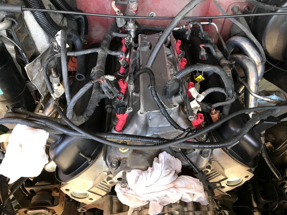 Engine with red fuel injectors and black wiring harnesses, viewed from above