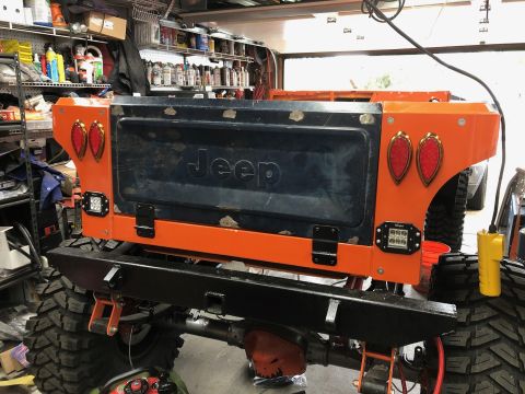 1992 Jeep Wrangler - Customized Jeep tailgate orange bodywork, "Jeep" branding, and modern LED lighting.
