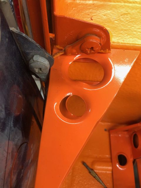 1992 Jeep Wrangler - A close-up view of a painted metal bracket, likely part of a door hinge mechanism on a vehicle.
