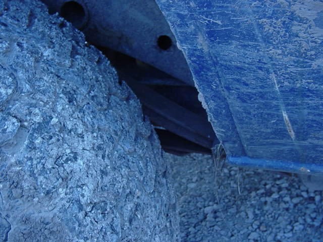 Close-up of a tire and blue painted undercarriage of a vehicle