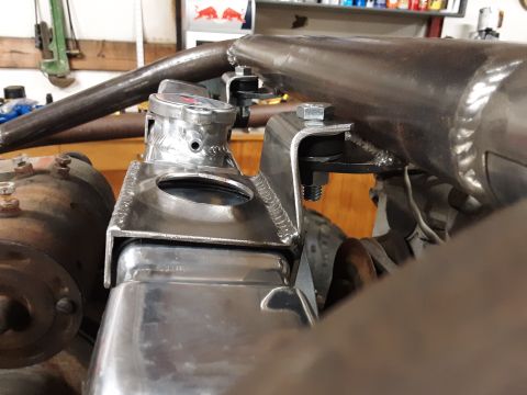 1985 Toyota Hilux - Close-up view of a custom-fabricated radiator and its polished cap, with surrounding metal tubing and engine components.