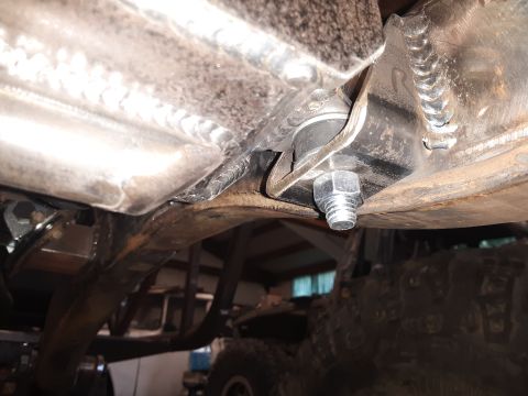1985 Toyota Hilux - Close-up view of the undercarriage, focusing on suspension components and a large bolt, with a tire visible in the background.