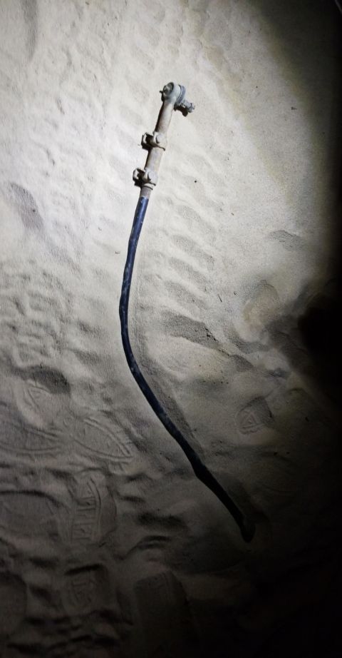 1996 Dodge 1500 - A single steering linkage part is visible against a sandy background with tire tracks.
