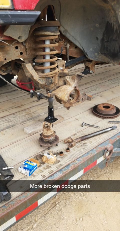 1996 Dodge 1500 - Broken Dodge truck suspension parts are laid out on a trailer for repair or replacement.