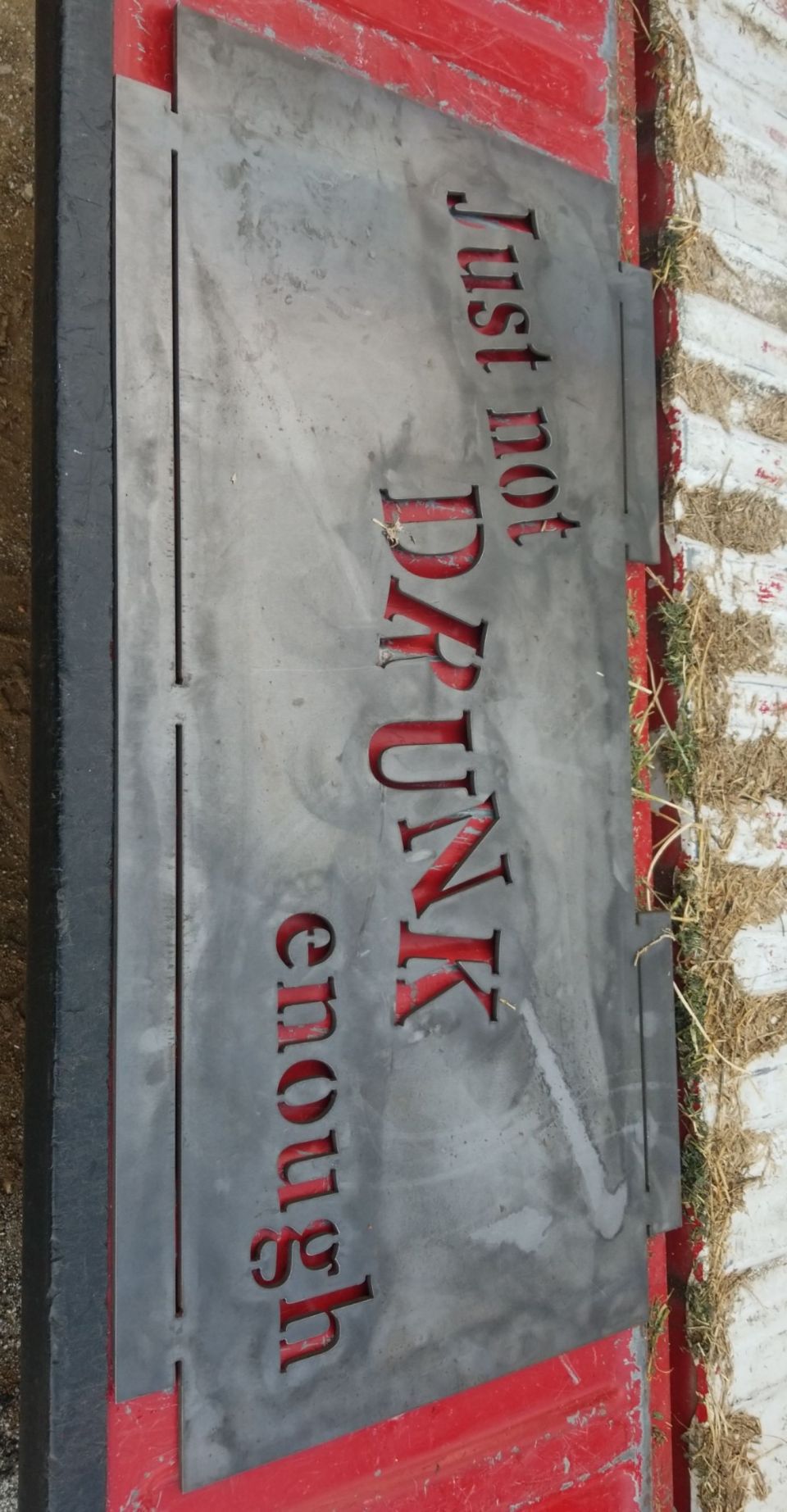 Metal sign with cut-out text 'Just not DRUNK enough' and a Nike swoosh