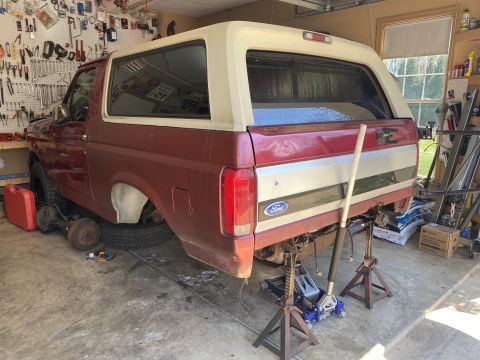 1994 Ford Bronco - Rear end of a 1994 Ford Bronco undergoing repairs in a garage setting.