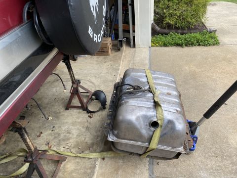 1994 Ford Bronco - Spare tire cover with Bronco text is visible during a rear end rebuild.