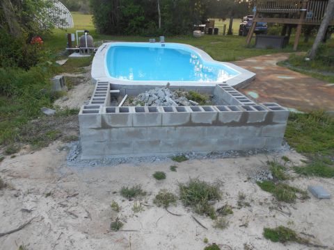 1992 Ford Bronco - A swimming pool is being constructed, surrounded by a cinder block wall and pool equipment.