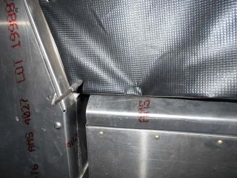 1992 Ford Bronco - Close-up of metal panel with red ink markings and insulation, likely a vehicle part.