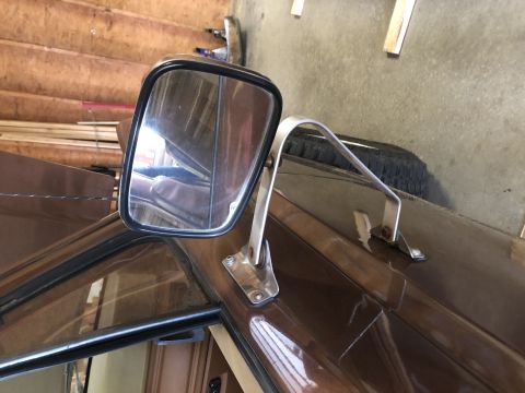 1980 Ford Bronco - Side mirror assembly attached to the roof of a brown vehicle, possibly an older SUV or truck.