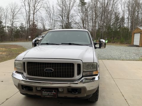 2002 Ford Excursion - This white Ford Excursion, likely from the early 2000s, is shown from the front with its large tow mirrors extended.