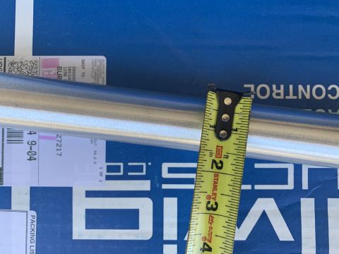 2002 Ford Excursion - A metal pipe is measured with a tape measure, with shipping labels and text visible in the background.