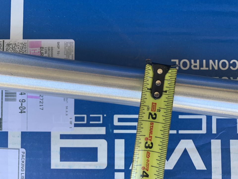 Metal pipe with a yellow Stanley measuring tape against a blue background with white text