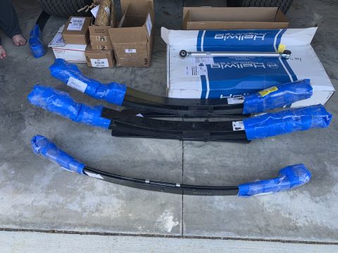 2002 Ford Excursion - New Hellwig suspension parts, including leaf springs and a sway bar kit, laid out on a concrete surface.