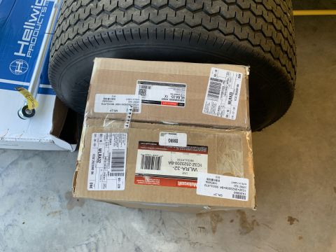 2002 Ford Excursion - Boxes of parts and a tire are stacked on a concrete floor.