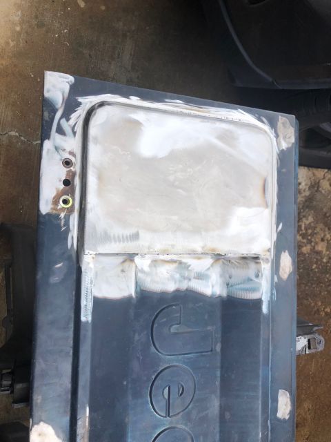 1992 Jeep Wrangler - Tailgate repair in progress, showing body filler and welding on the embossed 'JEEP' logo.
