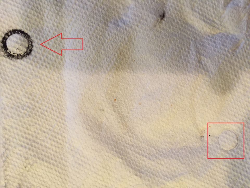 Paper towel with a black circular residue mark and a faint ring, annotated with red arrow and box