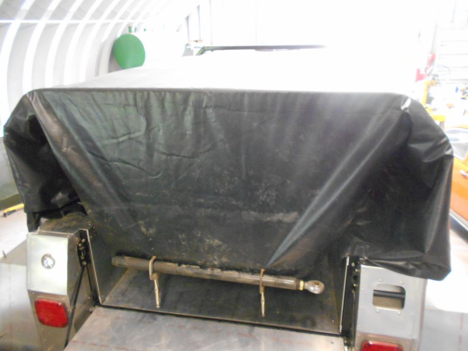 Trailer hitch mechanism with a black tarp covering the top