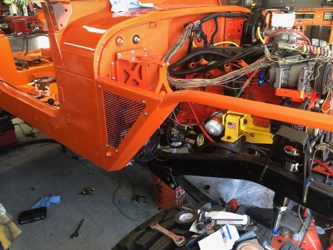 1992 Jeep Wrangler - An orange Jeep Wrangler is in a state of reassembly, with its engine and chassis components visible.