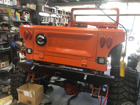 1992 Jeep Wrangler - Orange Jeep CJ tailgate and rear panels are visible, possibly undergoing restoration or modification in a workshop.