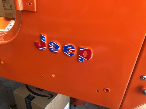 1992 Jeep Wrangler - Close-up of an orange Jeep body panel displaying custom emblems with a Confederate flag design.