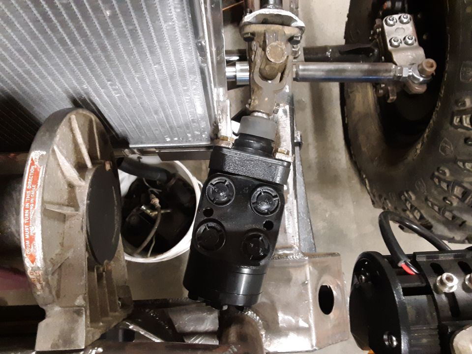 Black steering component near a radiator and a tire