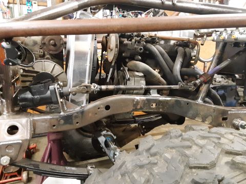 1985 Toyota Hilux - Close-up view of the engine bay and suspension system of a modified vehicle, likely undergoing restoration or customization.