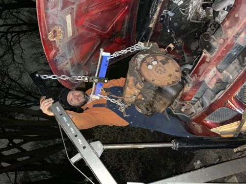2000 Pontiac Grand Prix - Engine removal in progress with a hoist supporting the powertrain.