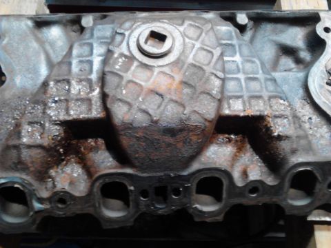 1978 Ford Bronco - Close-up view of an engine intake manifold, showing its textured surface and a central bolt head.