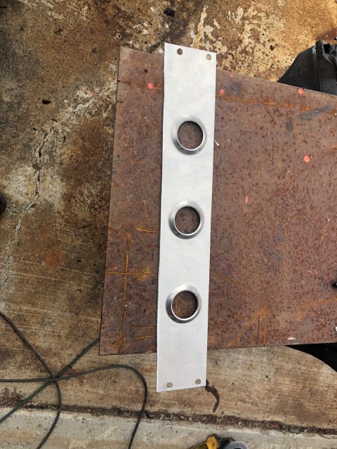1992 Jeep Wrangler - A metal plate with three evenly spaced circular cutouts rests on a rusty surface.