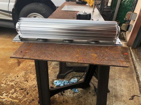1992 Jeep Wrangler - A large, finned aluminum heat sink is shown on a workbench, with a portion of a white vehicle visible in the background.