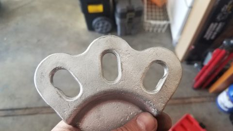 1985 Ford Bronco - A metal component with three openings is examined, with a Supermotors watermark visible.