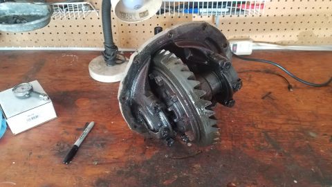 1985 Ford Bronco - A differential assembly is shown on a workbench, with a marker and a gauge nearby.