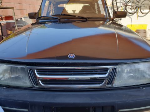 1991 Saab 900 - Front view of a black 1991 Saab 900, its distinctive grille and emblem. The vehicle appears to be in a garage setting.