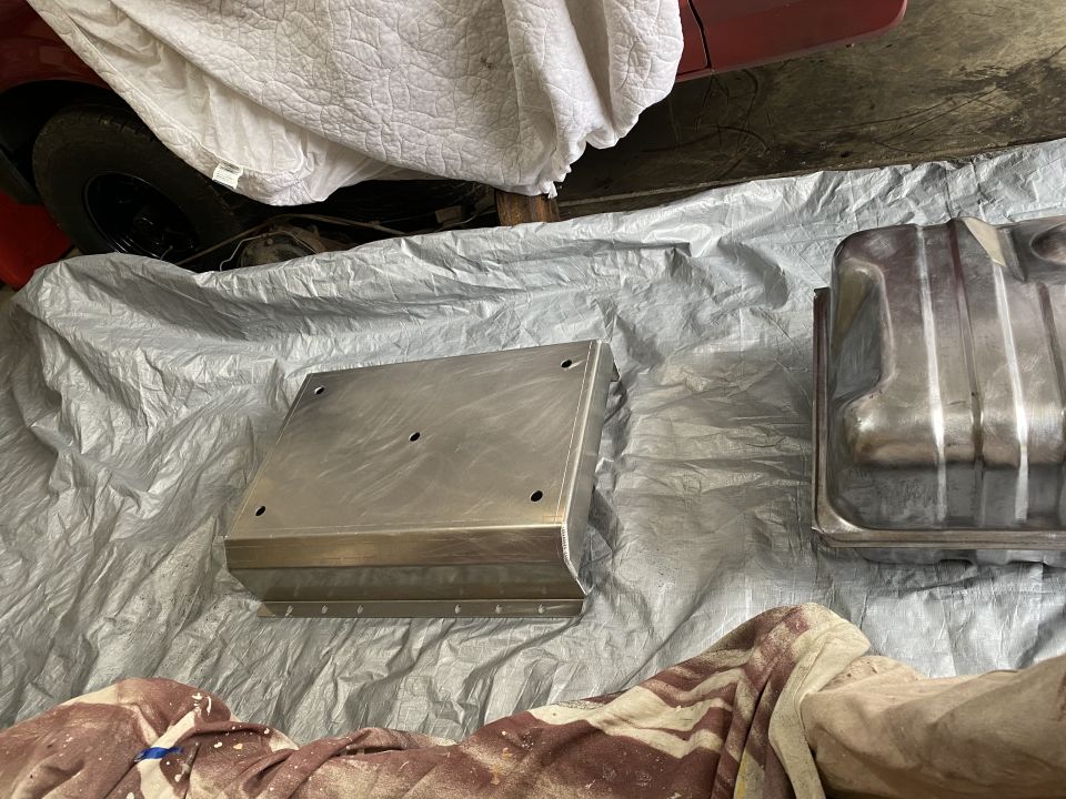 Metal fuel tank and aluminum skid plate on tarp