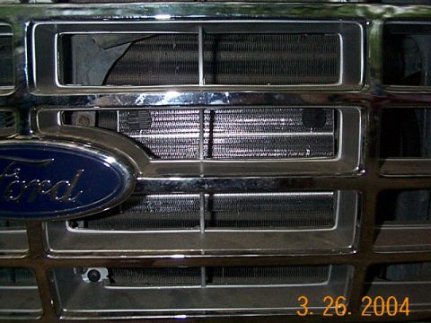 1986 Ford Bronco - Close-up of a Ford truck's chrome grille and radiator.