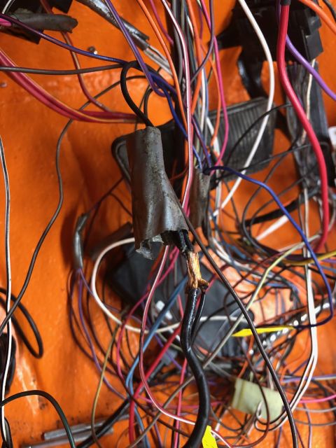 1992 Jeep Wrangler - A complex web of wires, some frayed and exposed, against an orange interior panel.