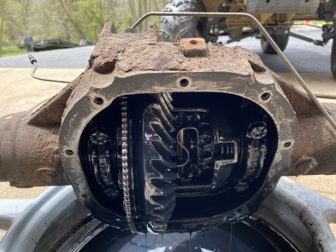 1994 Ford Bronco - Differential housing opened to reveal internal gears and chain mechanism, with oil visible.